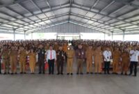 Bupati dan Wakil Bupati serta para narasumber melaksanakan foto bersama Kepala Desa dan Lurah se-Kabupaten Toba dalam acara sosialisasi peraturan di Sopo Parsaoran Tambunan, Kecamatan Balige, pada Senin (5/5/2025).