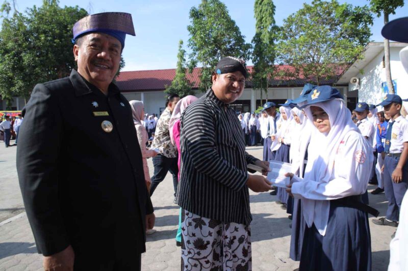 Bupati Asahan Taufik Zainal Abidin, S.Sos., M.Si., dan Wakil Bupati Asahan, Rianto, S.H., M.A.P., saat menyerahkan secara simbolis buku rekening Program Indonesia Pintar (PIP) kepada 75 siswa penerima manfaat. Jumat, (02/05/2025)