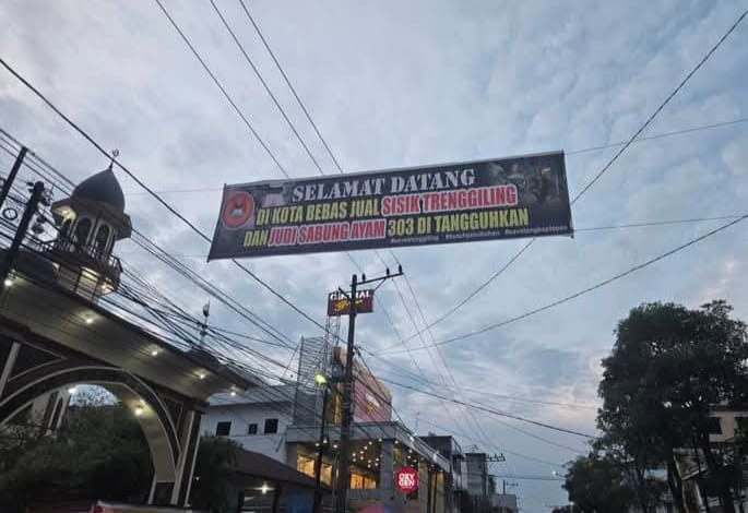 Dewan Pimpinan Pusat Perhimpunan Mahasiswa Asahan Seluruh Indonesia (DPP PERMASI) membentangkan spanduk bernada satir di Jalan Imam Bonjol, dekat Masjid Raya Kota Kisaran, pada Sabtu (31/5/2025).