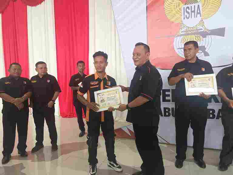 Ketua panitia, Deni Hendra Sitepu (kanan) menyerahkan piagam penghargaan kepada salah seorang peserta kejuaraan menembak, Kamis (26/6/2025).