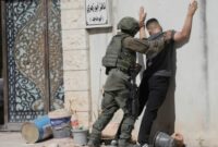 Seorang tentara Israel menggeledah seorang pria Palestina di kamp pengungsi Tulkarem, Tepi Barat yang diduduki, pada 6 Juli. (Sumber foto: Majdi Mohammad/AP Photo)
