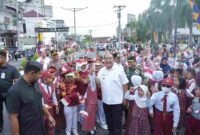 Bupati Taufik Zainal Abidin, S.Sos., M.Si.,  saat menikmati momen berbagi bendera dengan siswa SD. Rabu (6/8)