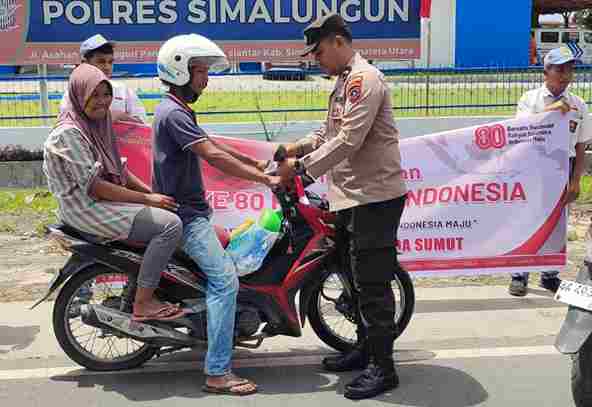 Saat sebuah kendaraan diberhentikan dan diberikan bendera Merah Putih oleh personil Polres Simalungun. Rabu, (6/8)