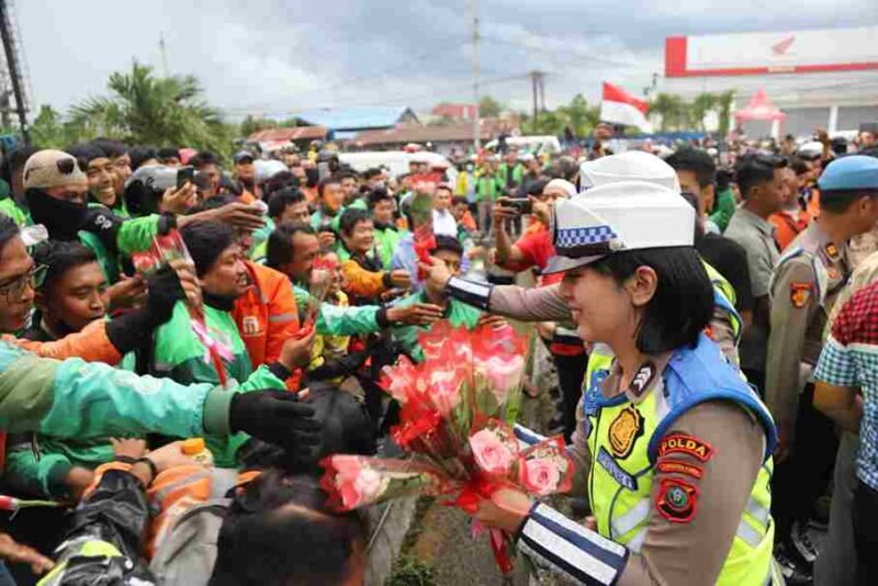 Saat salah seoranh Polwan Polda Sumut berbagi bunga dengan para ojol. Senin, (1/9)