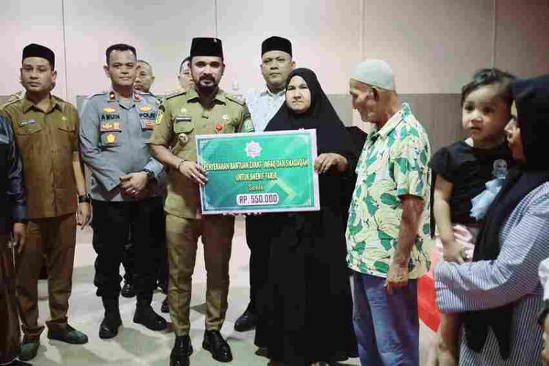 Bupati Aceh Timur, Iskandar Usman Al-Farlaky, S.H.I., M.Si., menyalurkan secara simbolis dana Zakat, Infak, dan Sedekah (ZIS) yang dikelola Baitul Mal Kabupaten Aceh Timur, Senin (20/10/2025) di Aula Graha Bunda, Idi.
