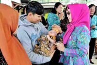 Ketua Tim Penggerak Pemberdayaan Kesejahteraan Keluarga (TP PKK) Kabupaten Simalungun, Ny. Hj. Darmawati Anton Achmad Saragih, saat menyambangi salah seorang bayi.