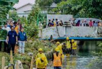 Wali Kota Medan Rico Tri Putra Bayu Waas menyusuri pinggiran Sungai Batuan yang dipenuhi pecahan keramik, sampah, dan semak belukar saat meninjau aliran sungai di Jalan Sumber Amal, Kelurahan Harjosari II, Kecamatan Medan Amplas, Selasa (9/12/2025). 