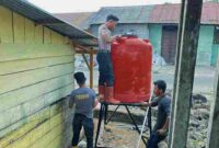 Personil brimob saat memasang toren air untuk air bersih warga.