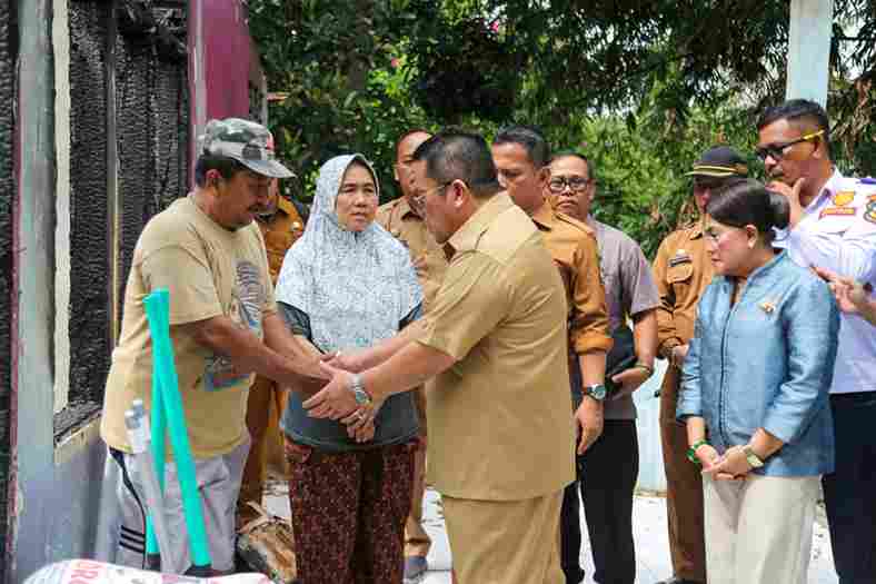 Wali Kota Pematangsiantar, Wesly Silalahi, S.H., M.Kn., didampingi Ketua TP PKK Kota Pematangsiantar, Ny. Liswati Wesly Silalahi, menyerahkan bantuan kepada keluarga Sulfan Solihin (63), korban kebakaran rumah di Jalan Kasuari, Kelurahan Sipinggol-pinggol, Kecamatan Siantar Barat, pada Selasa, 20 Januari 2026.