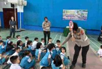Salah seorang Polwan sedang menunjukkan tanda rambu lalu lintas kepada Anak-anak. 