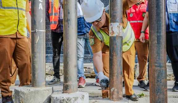Pelaksana Tugas Kepala Dinas Sumber Daya Air, Bina Marga, dan Bina Konstruksi (SDABMBK) Kota Medan, Gibson Panjaitan, saat melakukan pemotongan tiang kabel optik. 