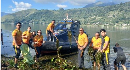 Personil Polres Samosir saat bersih-bersih di tepi Pantau Danau toba.