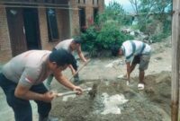 Personil Brimob bantu warga membangun rumah.