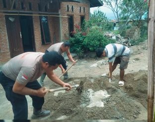 Personil Brimob bantu warga membangun rumah.