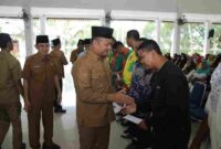 Wakil Bupati Asahan secara simbolis menyerahkan bantuan zakat kepada sejumlah petugas kebersihan dari Dinas Lingkungan Hidup Kabupaten Asahan.