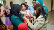 Ketua TP PKK Kota Pematangsiantar, Liswati Wesly Silalahi, saat menyapa salah seorang bayi yang sedang di gendong. 