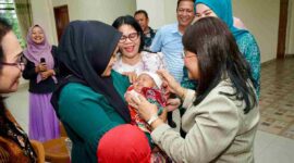 Ketua TP PKK Kota Pematangsiantar, Liswati Wesly Silalahi, saat menyapa salah seorang bayi yang sedang di gendong. 