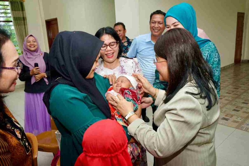 Ketua TP PKK Kota Pematangsiantar, Liswati Wesly Silalahi, saat menyapa salah seorang bayi yang sedang di gendong. 