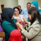 Ketua TP PKK Kota Pematangsiantar, Liswati Wesly Silalahi, saat menyapa salah seorang bayi yang sedang di gendong. 