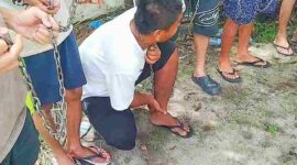 Hotman, warga asal pekanbaru dan juga seorang pasien NAZPA memperagakan saat leher dan kaki dirantai. 