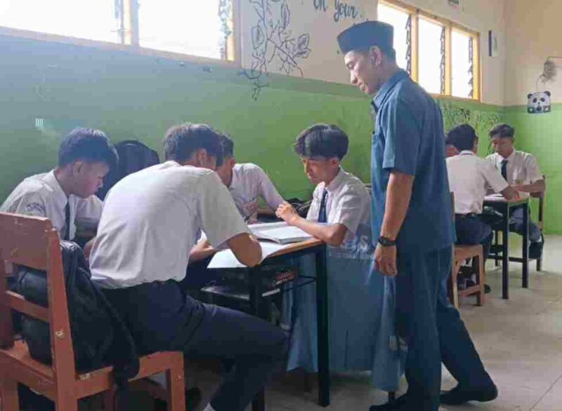 Salah seorang guru terlihat sedang melihat kelompok belajar siswa didalam ruang kelas. (Foto:Ist)
