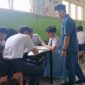 Salah seorang guru terlihat sedang melihat kelompok belajar siswa didalam ruang kelas. (Foto:Ist)