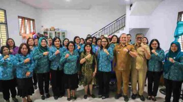 Ketua TP PKK Kota Pematangsiantar Ny. Liswati Wesly Silalahi menyerahkan tali asih kepada kader yang terdampak kebakaran Pasar Dwikora.