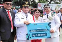 Wali kota Pematangsiantar, wesly Silalahi, SH.,M.Kn, didampingi Istri dan kadis LH Kota pematangsiantar Arri Sembiring, S.STP.,M.Si saat menyerahkan Piala dan hadiah kepada Lurah Kahean, Aprita pronika Sagala, S.Si., M.Si. pada Hut RI ke 81 Tahun di lapangan Adam Malik Pematangsiantar.
