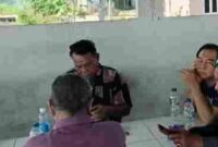 Sosok Akiang saat duduk dan diapit wartawan. 