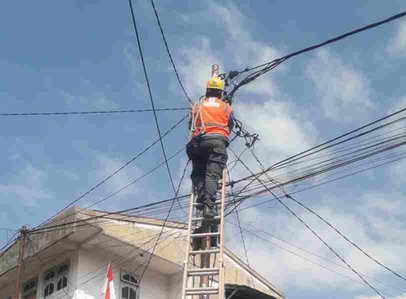 Petugas terlihat sedang melakukan perbaikan jaringan Listrik PLN. 