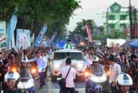 Warga menyambut iring-iringan Presiden di sepanjang perjalanan menuju lokasi acara.