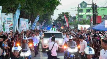 Warga menyambut iring-iringan Presiden di sepanjang perjalanan menuju lokasi acara.